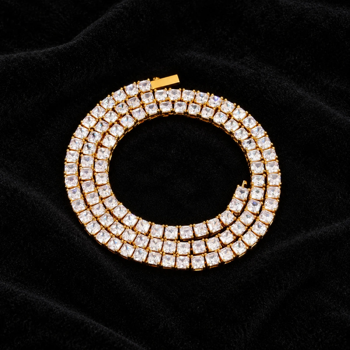 5mm Baguette Tennis Chain on black velvet — yellow gold coiled view with moissanite fire